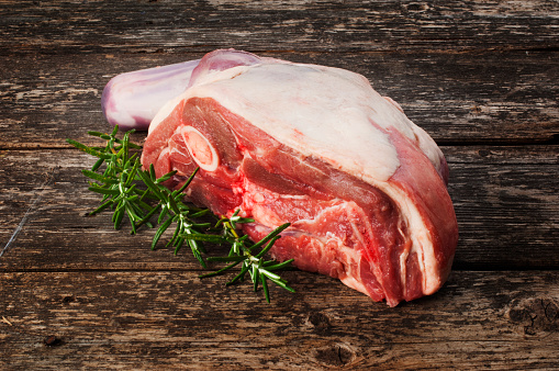 Raw shoulder of lamb against an old wood background