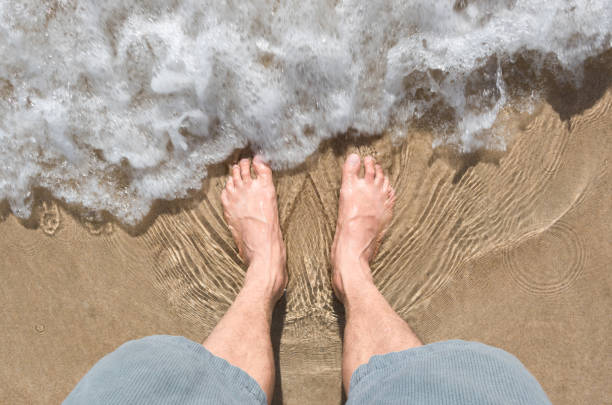 foot and sea wave on the beach.