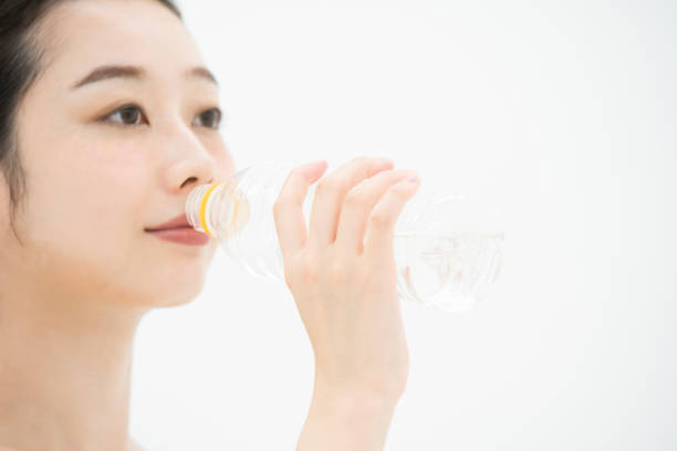 istock Young Asian (Japanese) woman drinking water with a plastic bottle 1219390931