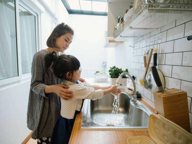 istock Millennial mother preparing breakfast at kitchen with her daugther's helping hand cooking omelet at home. 1219391009