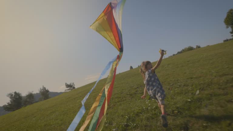 Playful little girl flying a kite, nostalgia.