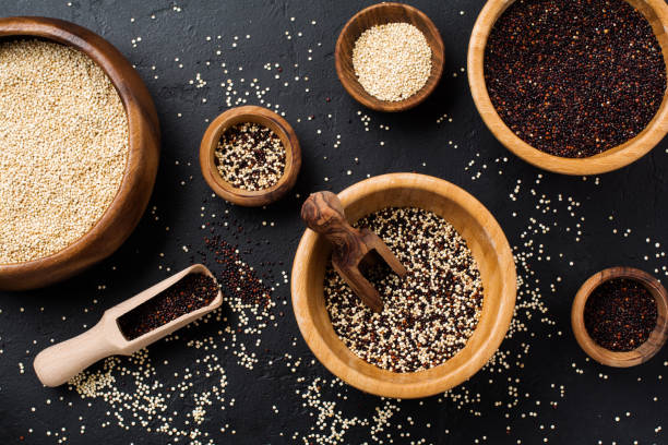 istock White, black and mixed quinoa grains seeds in a bamboo bowles on a black stone background. Flat lay with copy space. 1219393974
