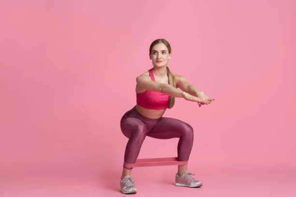 istock Beautiful young female athlete practicing on pink studio background, monochrome portrait 1219394417