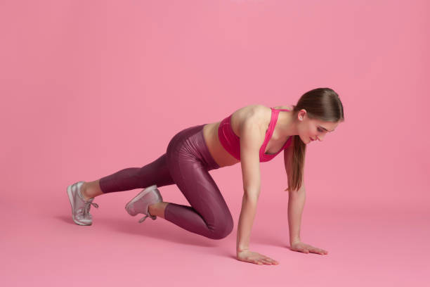 istock Beautiful young female athlete practicing on pink studio background, monochrome portrait 1219394469