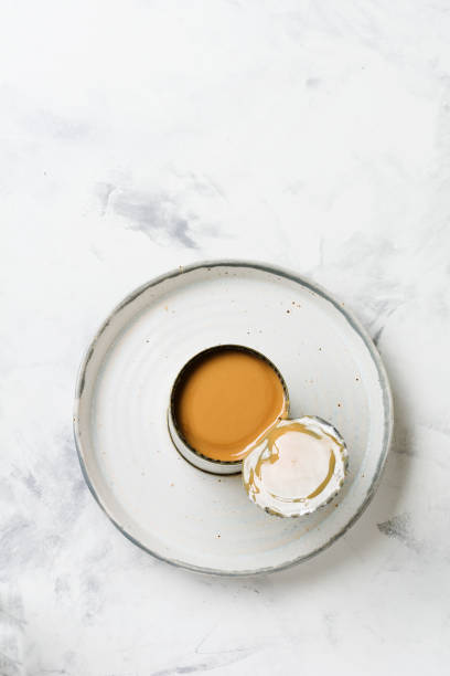 istock Condensed or evaporated milk in open tin on light concrete table. Top view. 1219394621