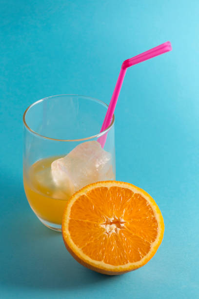 istock glass with orange juice and half orange 1219397657