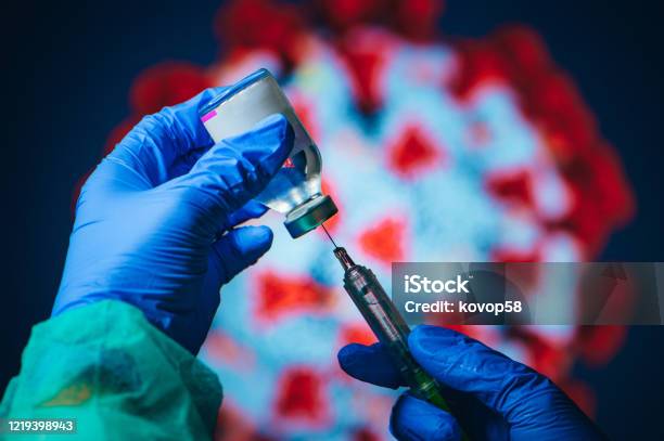 Coronavirus Covid19 Protection And Vaccine Doctor Drawing Up Solution From Vaccine Bottle And Filling Syringe Injection For Patient Vaccination In Medical Clinic Coronavirus In Background Stock Photo - Download Image Now