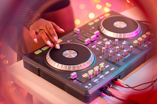 Mixing console is played by DJ and couples dancing on the dance floor in the background and empty space for text