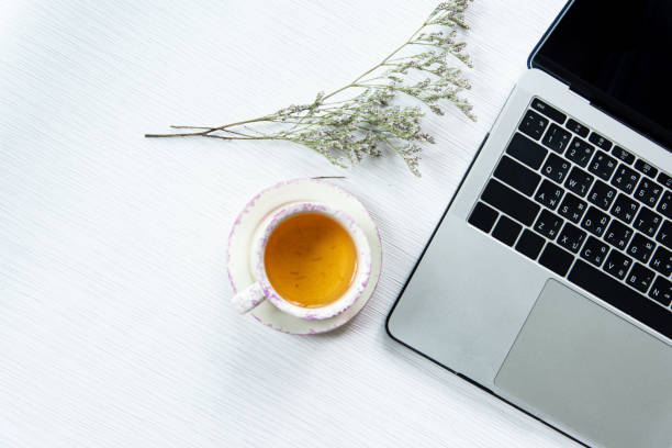istock Work from home, workspace office at home, Notebook or laptop computer with pen and Chinese tea cup  on the white desk at home office. 1219399659
