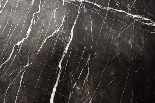 A slab of natural marble, black with white stripes veins, called Nero Marquina.