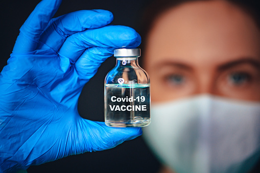 Coronavirus Covid-19 Protección y Vacunación. Primer plano del retrato, médico con un frasco de vacuna. Tittle en botella 