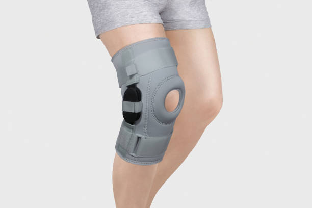 白い背景に分離された脚の膝サポートブレース。整形外科解剖学装具膝の固定、怪我や痛みのためのブレース。インソール。足の装具。膝関節包帯スリーブ。弾性スポーツ - 膝あて ストックフォトと画像