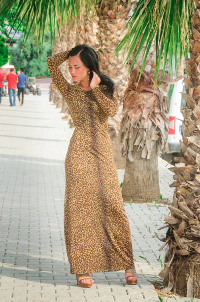 istock Brunette girl in a long leopard dress 1219401543