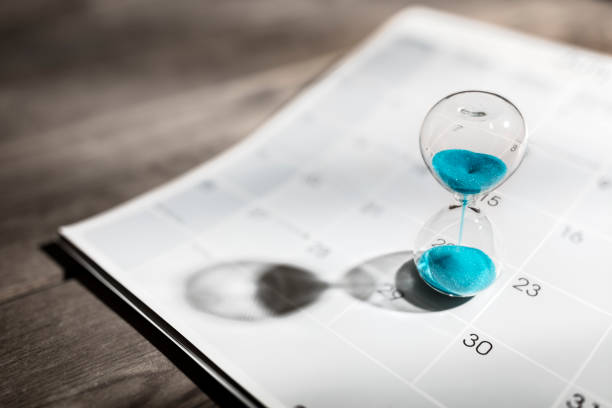 Hourglass on calendar appointment date, schedule and deadline Hour glass on calendar concept for time slipping away for important appointment date, schedule and deadline waiting stock pictures, royalty-free photos & images