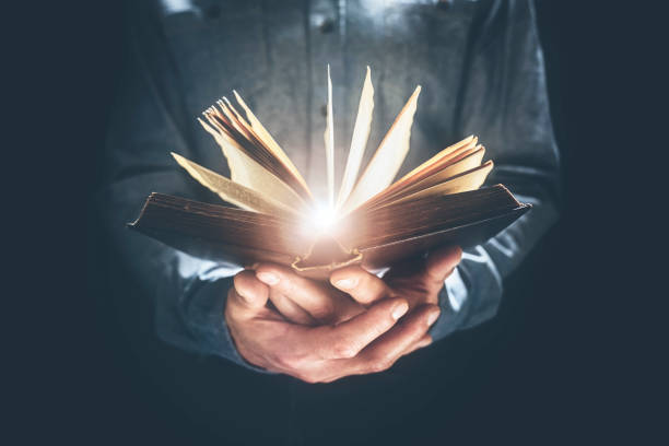 Man holding and reading the Holy Bible or a book Man holding and reading the Holy Bible or a hard cover book concept for religion or study jesus sharing stock pictures, royalty-free photos & images