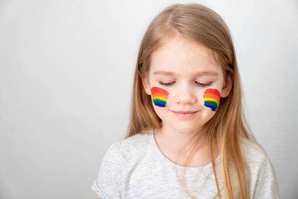 istock kid girl painted cheeks a rainbow. stay home. 1219402753