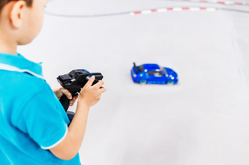 Kid playing with a toy car with wireless radio remote control