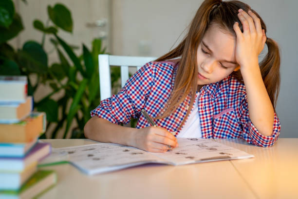 istock tired schoolgirl asleep doing homework. studying. 1219405839
