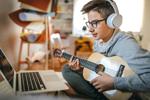 teenage boy having online guitar lesson - number 12 audio imagens e fotografias de stock