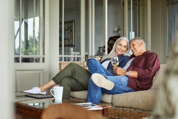 happy couple enjoying wine at home - senior adult cheerful adventure discovery imagens e fotografias de stock