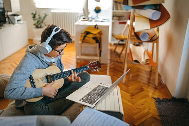 istock Teenage boy having online guitar lesson 1219408737