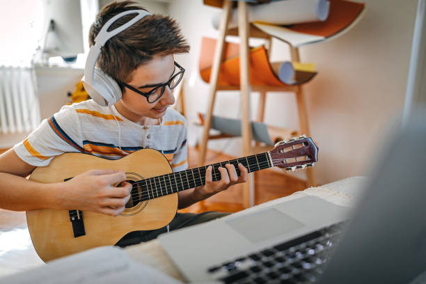 istock Teenage boy having online guitar lesson 1219408943
