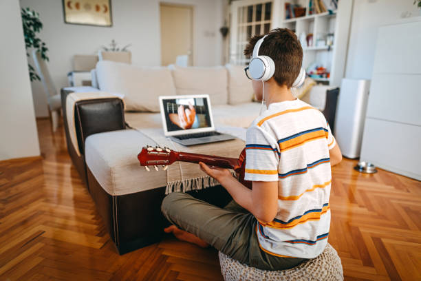 teenage boy having online guitar lesson - number 12 audio imagens e fotografias de stock