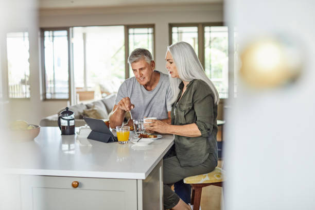 istock Couple watching news on tablet PC during breakfast 1219408984