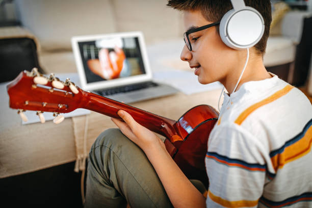 adolescente che ha una lezione di chitarra online - guitar child music learning foto e immagini stock