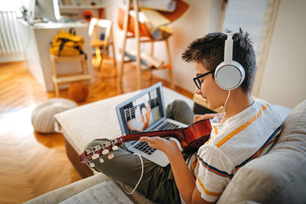 teenage boy having online guitar lesson - number 12 audio imagens e fotografias de stock