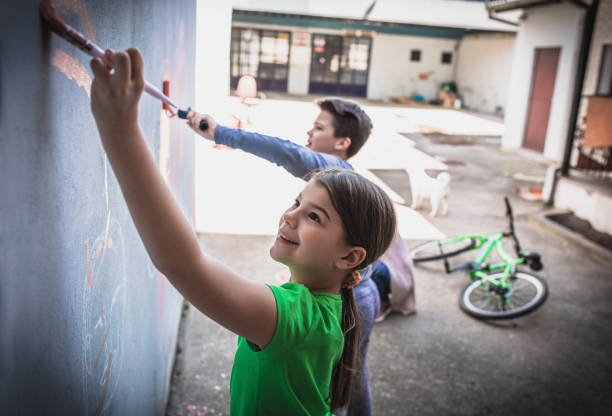 istock Two children draw paints  on a wall 1219410304