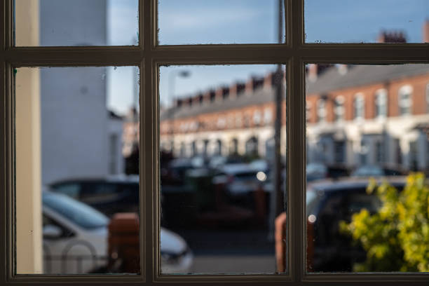 Viewpoint from interior of house through panels of front door towards front yard Viewpoint from interior of house through panels of front door  towards front yard and street beyond.  Selective focus.  Belfast, Northern Ireland. looking out front door stock pictures, royalty-free photos & images
