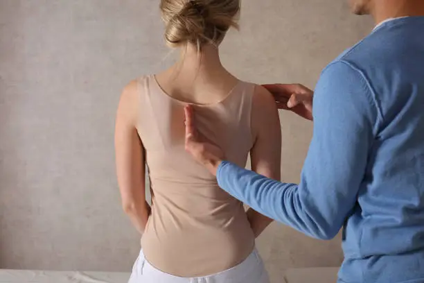 Photo of Woman having Chiropractic Back Adjustment / Physiotherapy Treatment . Scoliosis Posture Correction for Female Patient .