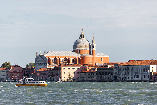 Venice, Italy - September 28, 2015 : Water channels of Venice city. Church of the Santissimo Redentore and Galleria Il Redentore buildings are on Grand Canal in Venice, Italy.