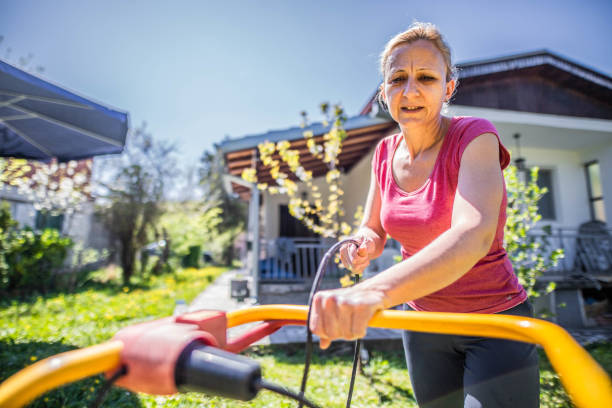 istock Women  mows  the grass while pandemic 1219414937