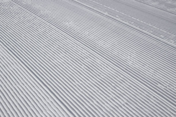 textur von frisch abgestreiften spuren auf schnee von schneekatze oder groomer, ratrack für konzept hintergrund skigebiet und winterurlaub - ski trace stock-fotos und bilder