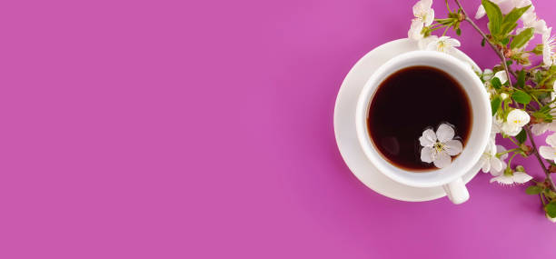 istock Blooming cherry, a cup of coffee on a colored background 1219417668