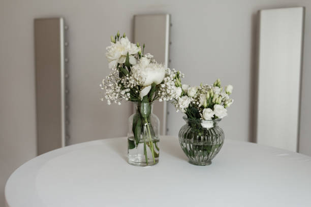 istock white Flowers composition in the vases on the white table. selective focus 1219417755