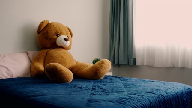 Empty bedroom with Teddy bear sitting on it. Warm look.
