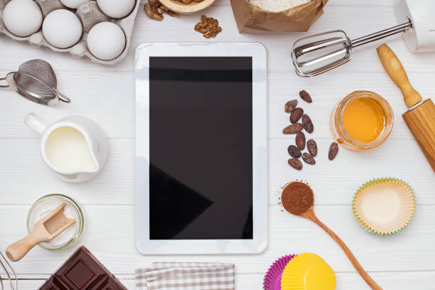 istock Ingredients and tools for baking and tablet with blank screen and place for text or image on white table 1219419053