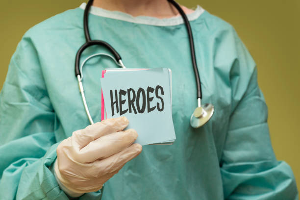 surgeon doctor holding paper with heroes concept surgeon doctor holding paper with heroes concept illness prevention photos stock pictures, royalty-free photos & images