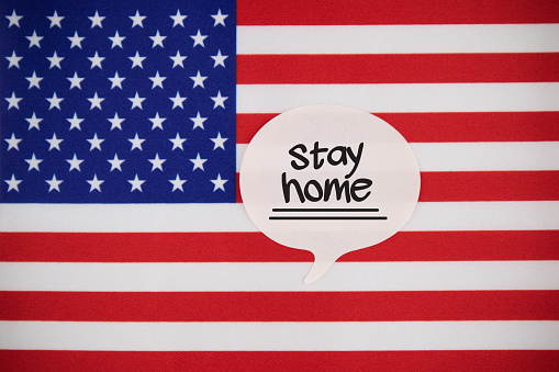 White Speech Bubble Note Paper With Stay Home Message On The USA Flag. Horizontal composition with copy space.