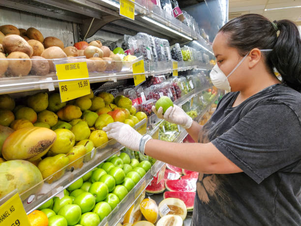 マスクと手袋を持つ緑のリンゴを選択する女性, コロナウイルスに対する保護 - cooking food lifestyles green ストックフォトと画像