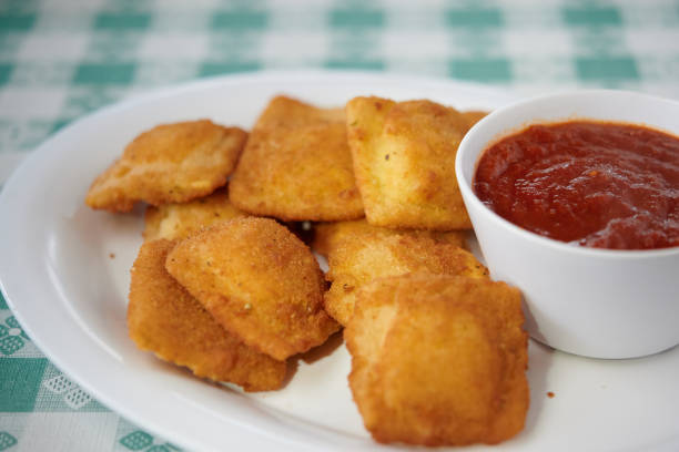 Fried ravioli on white plate with marinara sauce stock photo