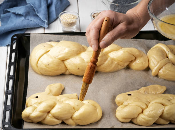 istock Easter pastries, challah, rabbit-shaped buns. Proofing baking before placing in the oven. Brush brush with butter buns before baking. Close-up. Shallow depth of field 1219426352