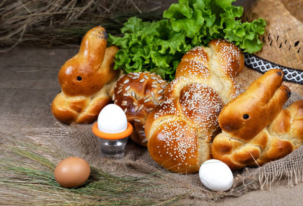 świeże wielkanocne wypieki, challah, bułeczki w kształcie królika. jajka i bułki znajdują się na burlap. zbliżenie. płytka głębia ostrości. plecione słodkie ciasto chlebowe - hanukkah loaf of bread food bread zdjęcia i obrazy z banku zdjęć