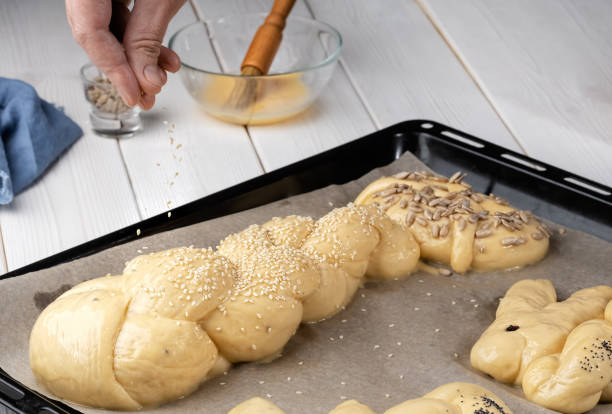 istock Sprinkle with sesame seeds buns. Easter pastries, challah, rabbit-shaped buns. Proofing baking before placing in the oven. Close-up. Shallow depth of field. Braided sweet bread dough 1219426396