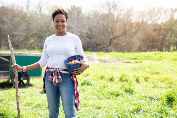 istock Female farmer smiles while holding basket of fresh eggs 1219427003