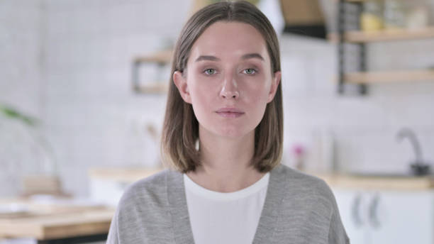 istock Serious Young Woman Looking at Camera 1219428106