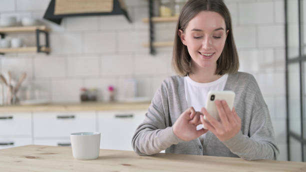istock Cheerful Young Woman using Smartphone with Coffee 1219428659